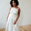 Model in a white long linen skirt with a matching sleeveless linen top