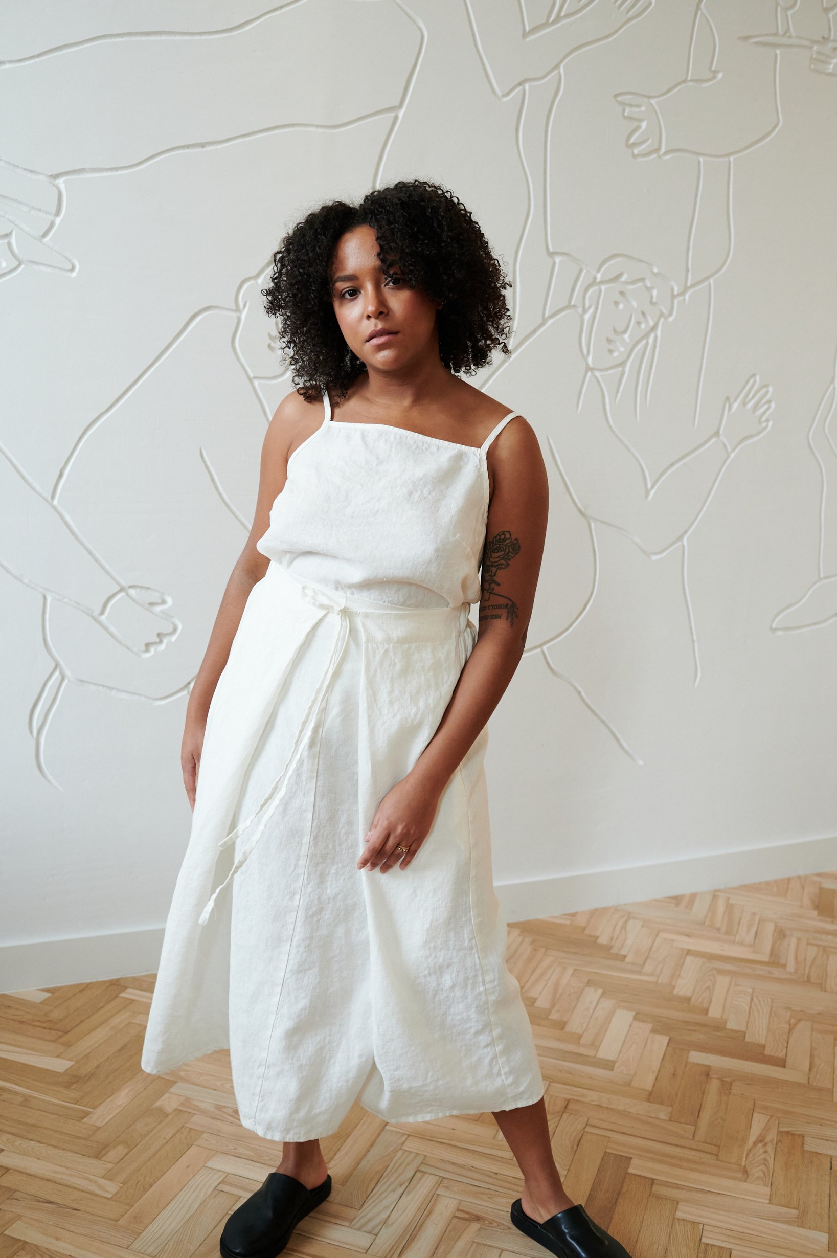 Model in a white long linen skirt with a matching sleeveless linen top