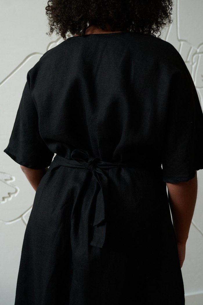 Black linen dress with short sleeves and a belt tied in the back