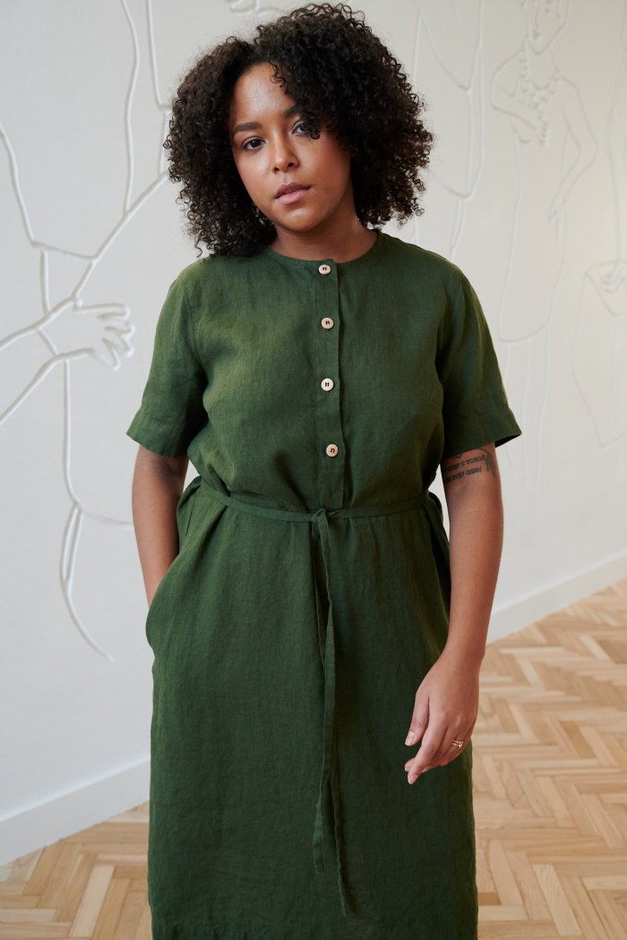 A woman in green linen midi dress with front buttons and a thin belt