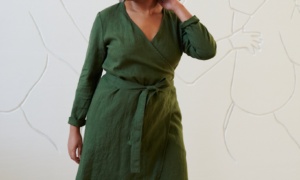 Model in a green linen wrap dress with long sleeves