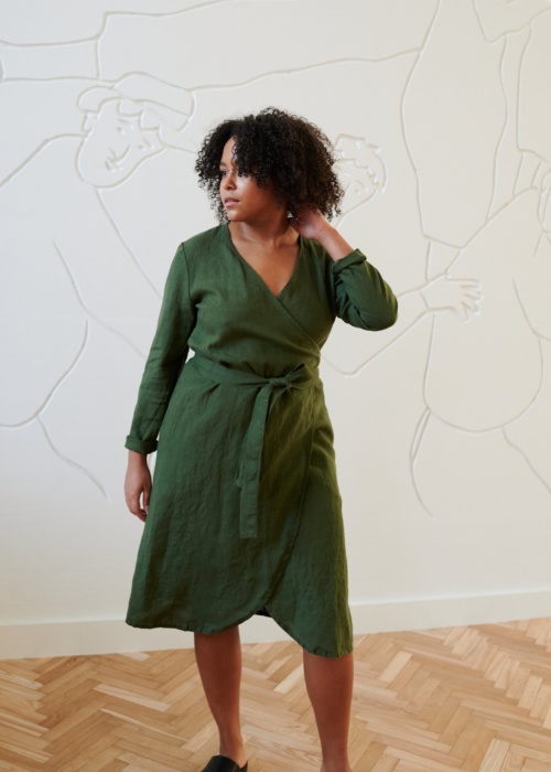 Model in a green linen wrap dress with long sleeves