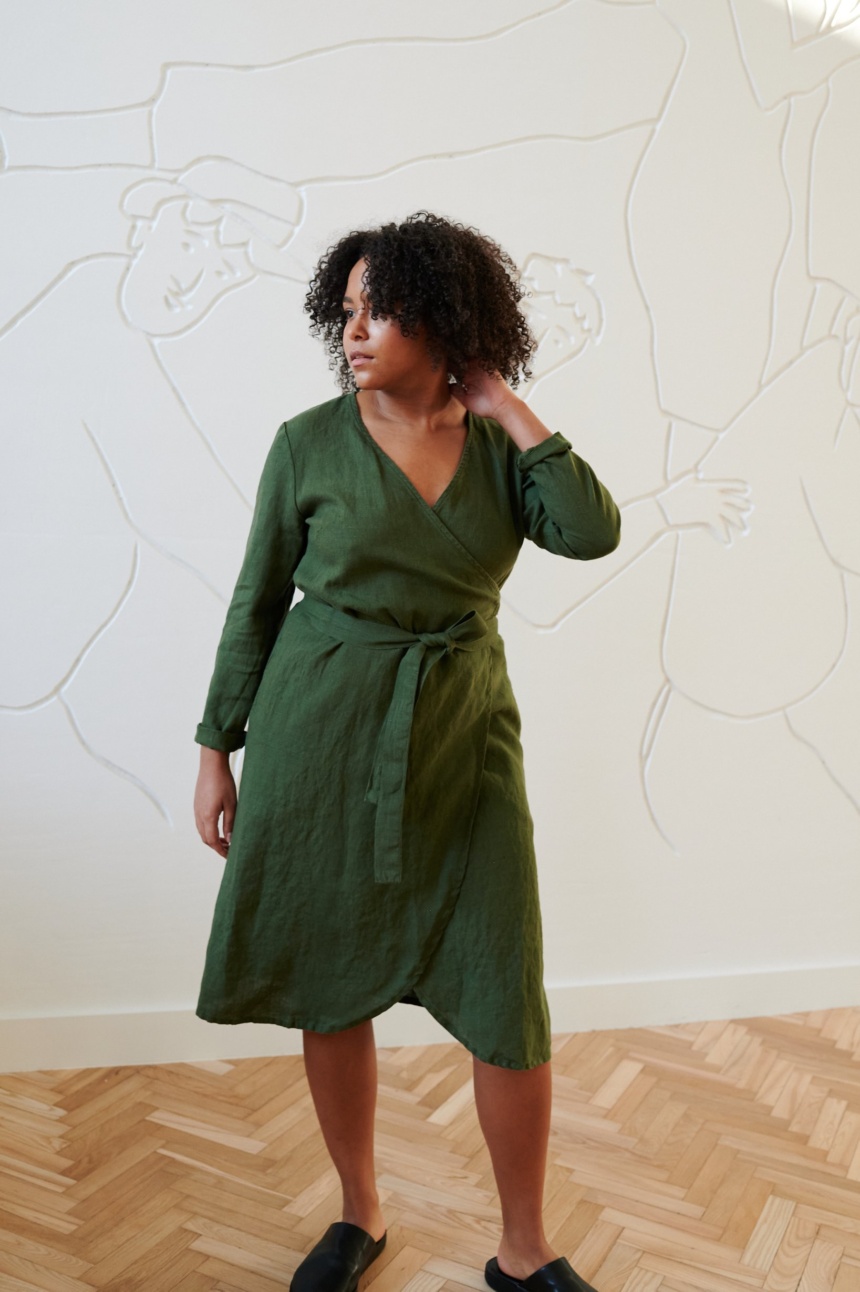 Model in a green linen wrap dress with long sleeves