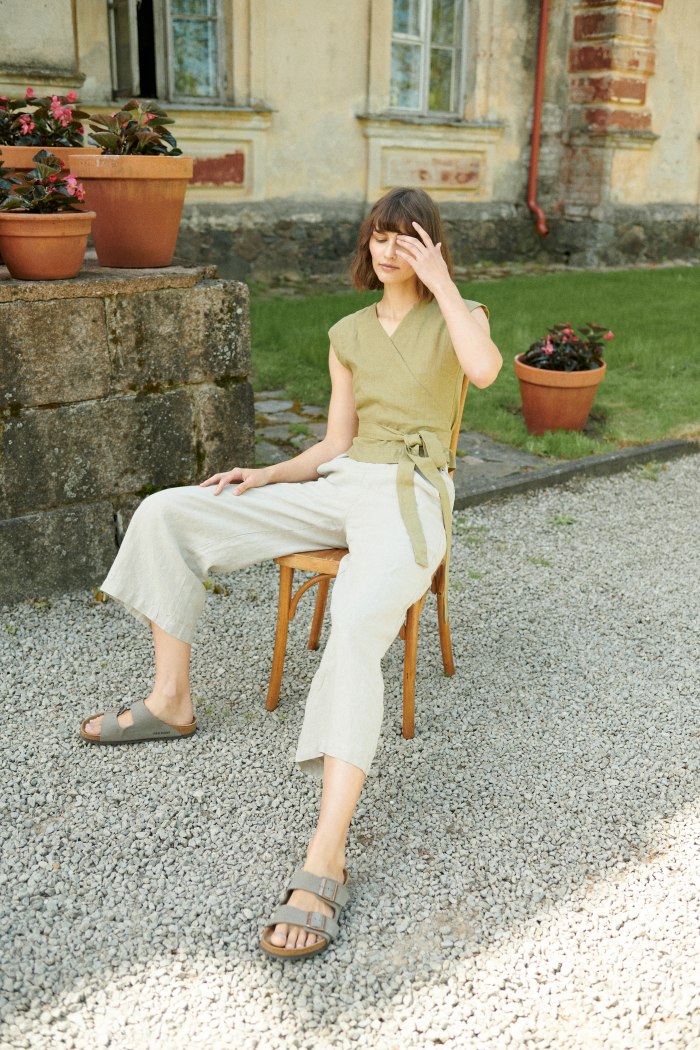 A woman in relaxed fit natural linen trousers
