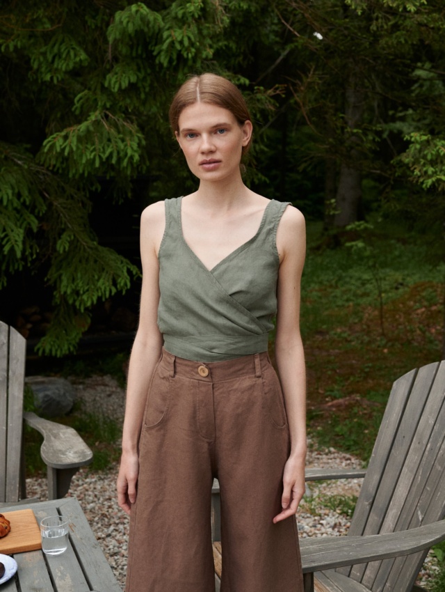 A woman wearing high waisted heavy linen trousers in brown