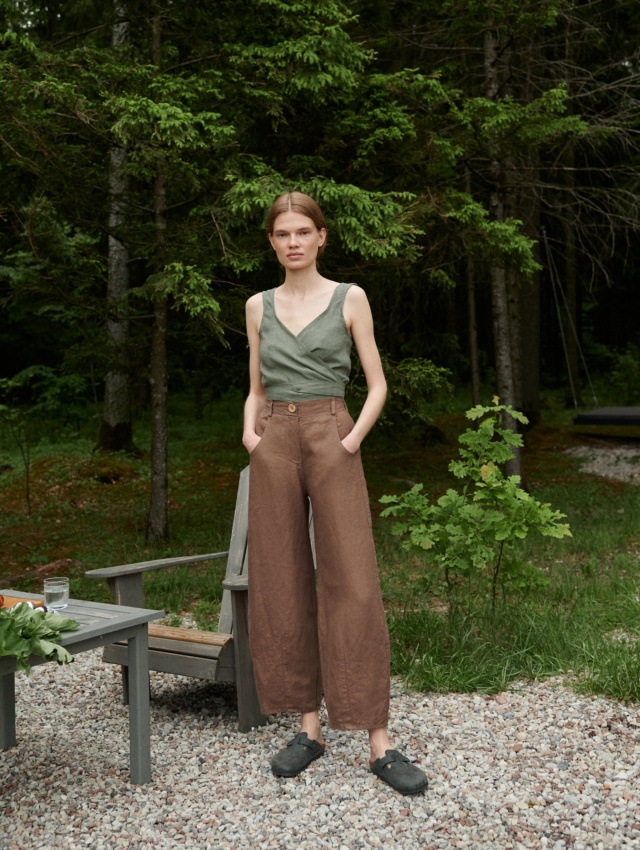 A woman in brown barrel leg heavy linen pants