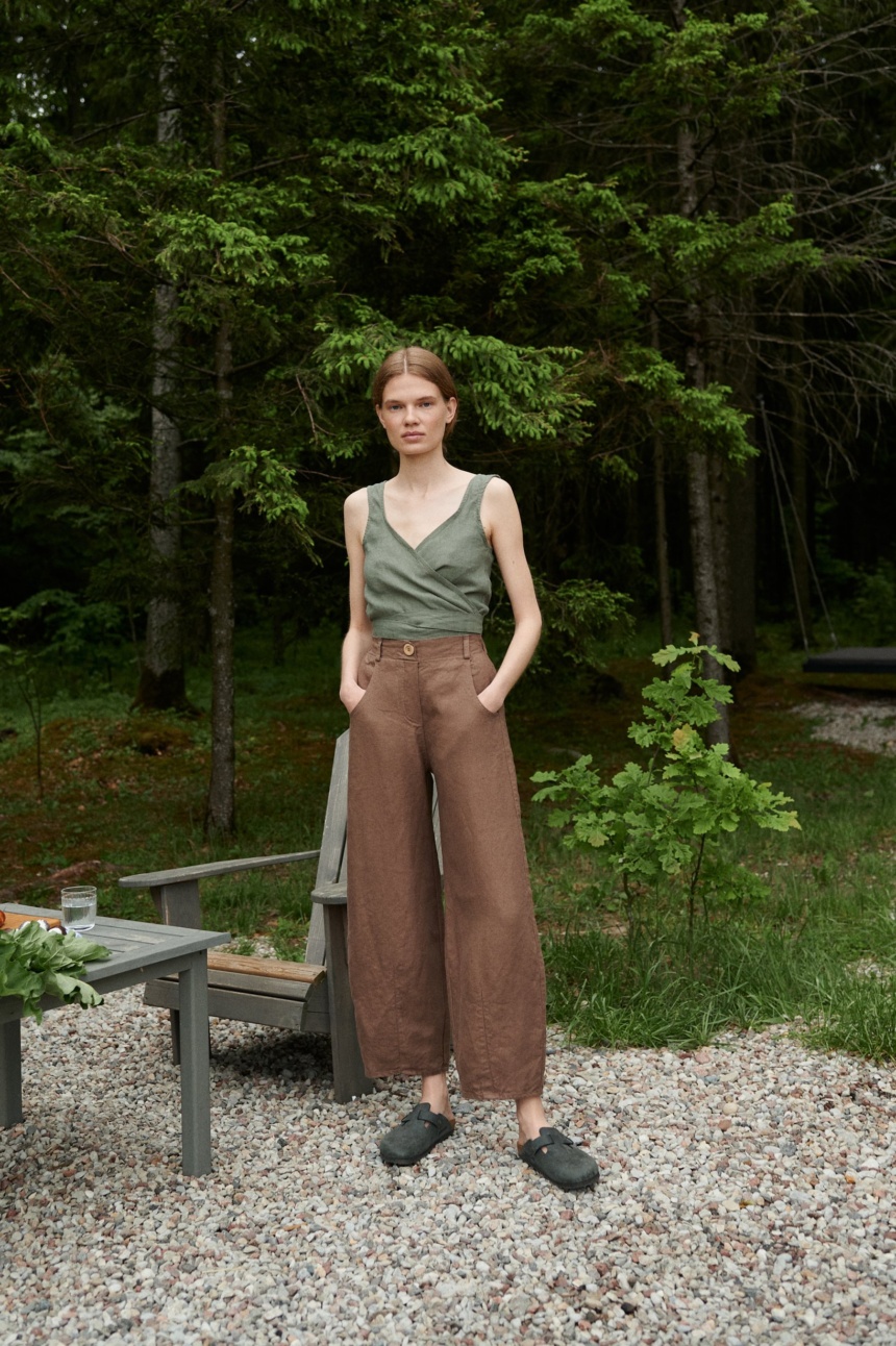 A woman in brown barrel leg heavy linen pants