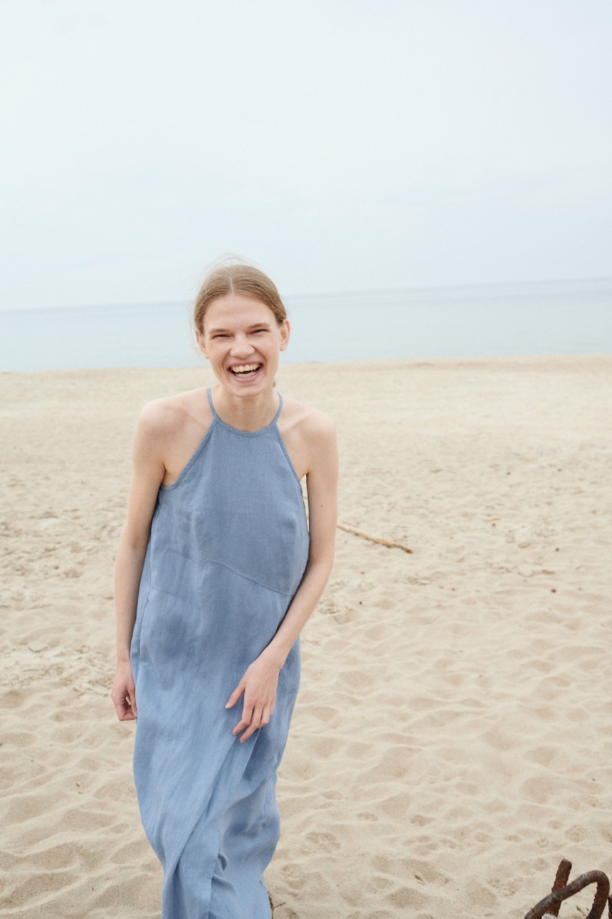 A sleeveless halter neck summer dress with an asymmetrical seam