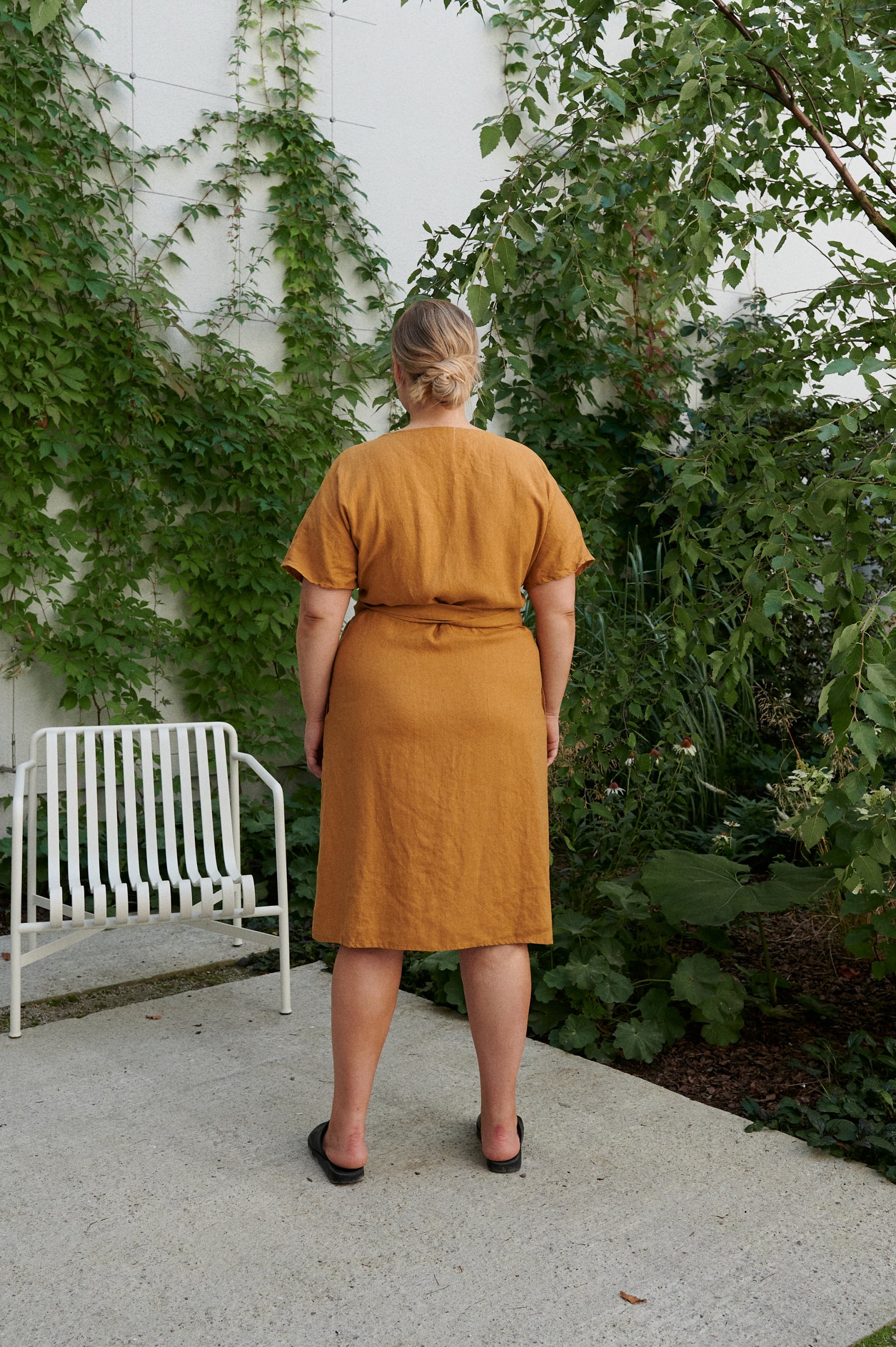 back of a woman in natural linen yellow dress
