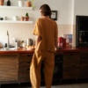A woman's back wearing dark yellow wide leg pants