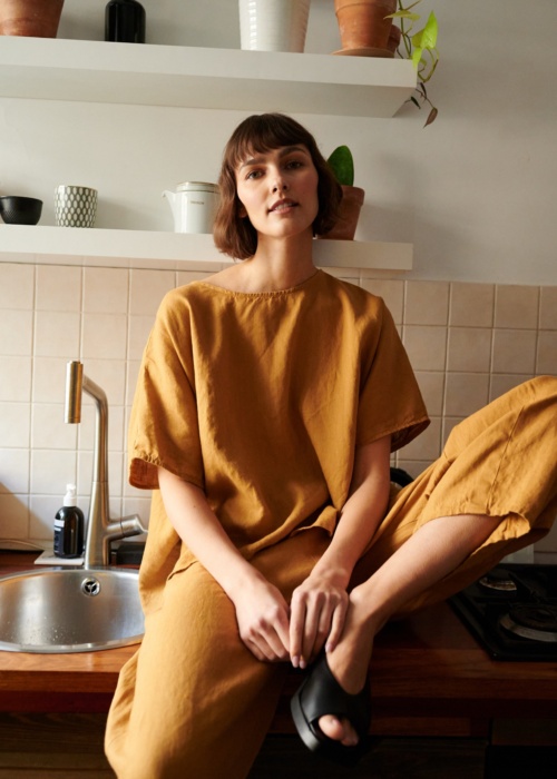 Model in loose-fitting linen trousers and an oversized linen top outfit