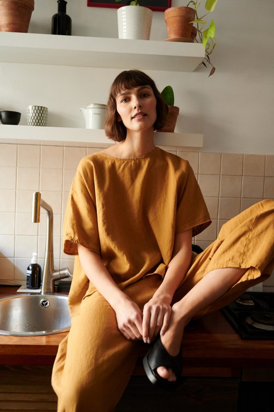 Model in loose-fitting linen trousers and an oversized linen top outfit