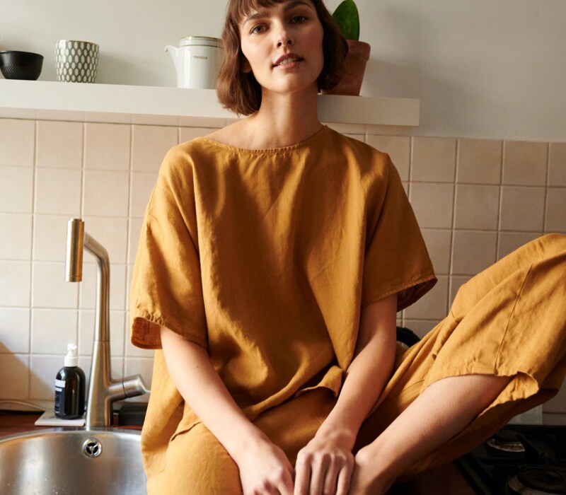 Model in loose-fitting linen trousers and an oversized linen top outfit