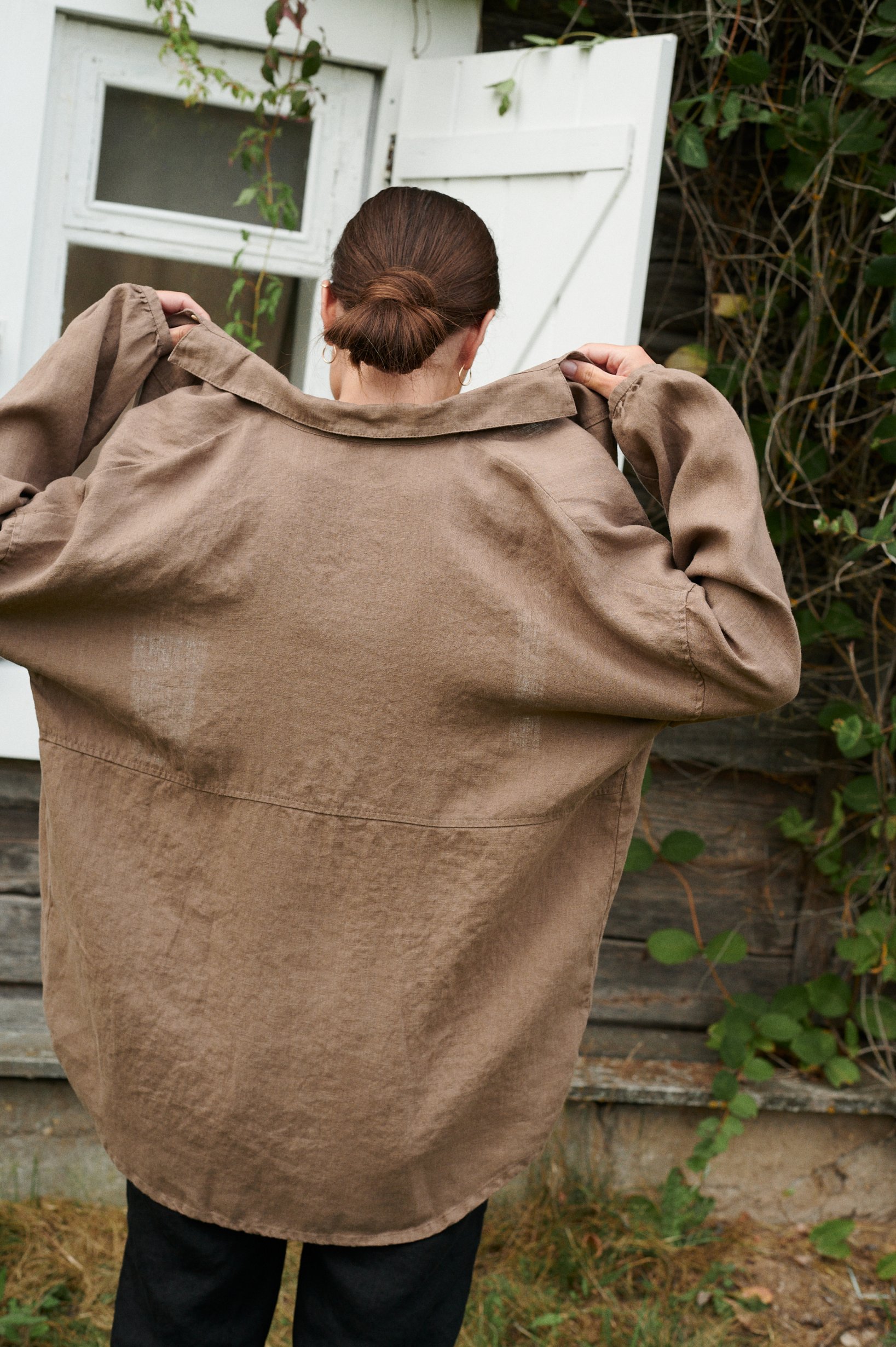 Woman's back in brown linen oversized button down