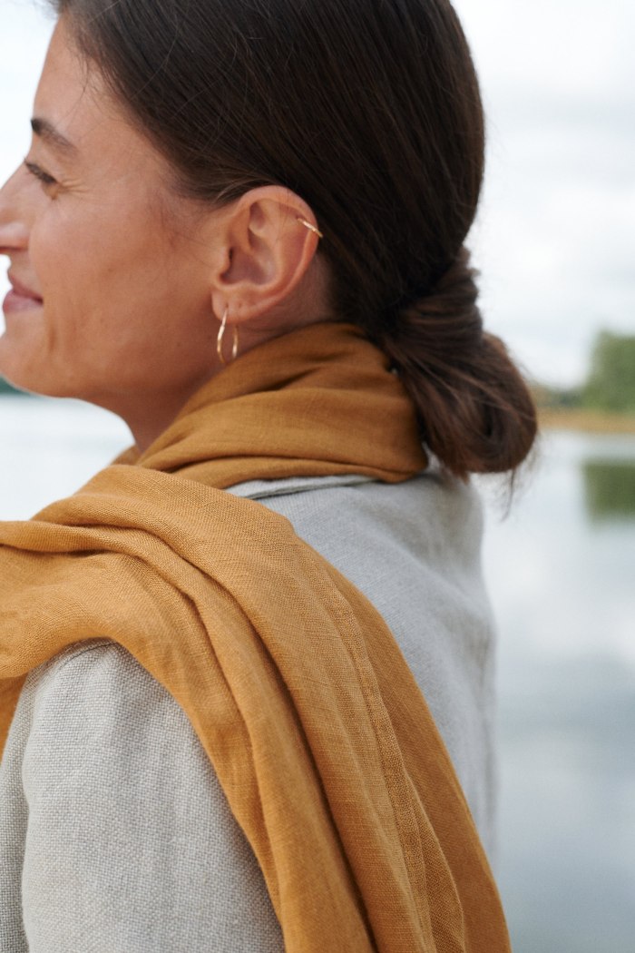 Natural linen scarf in camel color wrapped around the neck