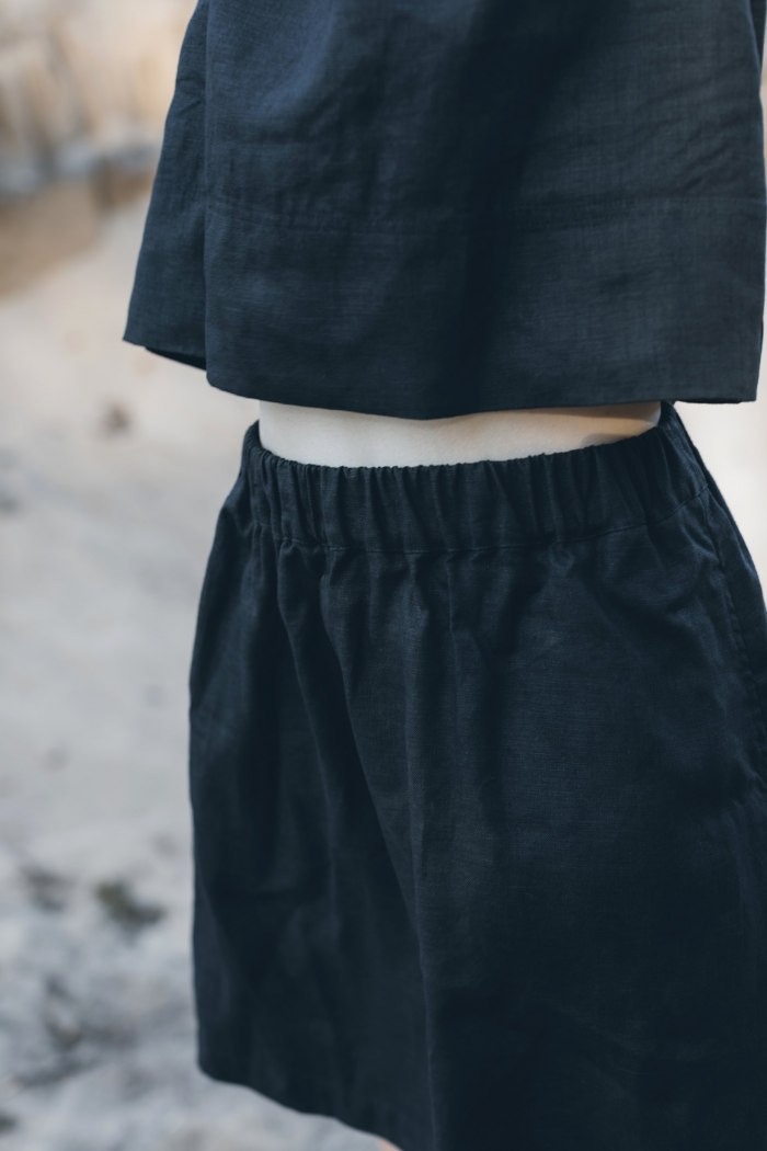 Fully elasticated waist of a plain black linen skirt