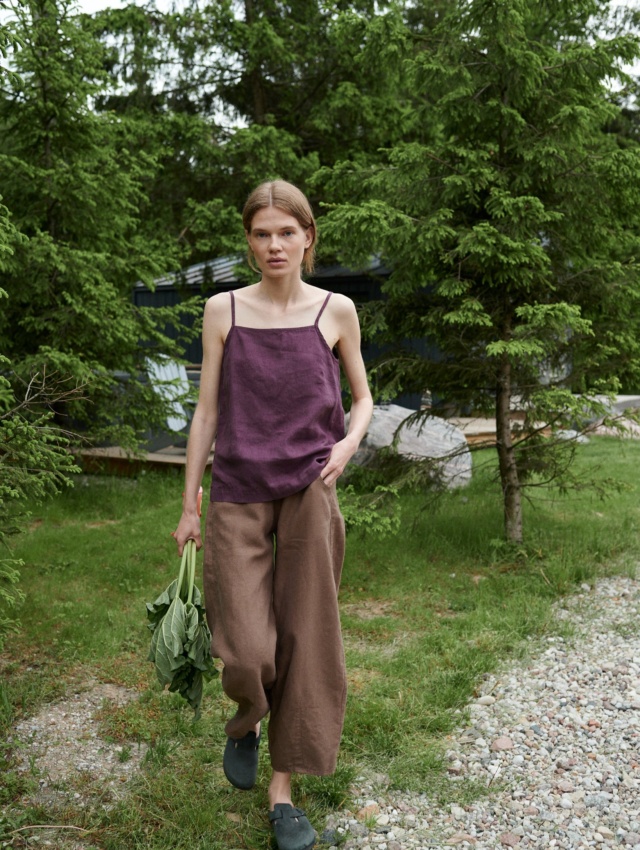 Woman walking while wearing a linen straight-cut top and wide leg linen trousers