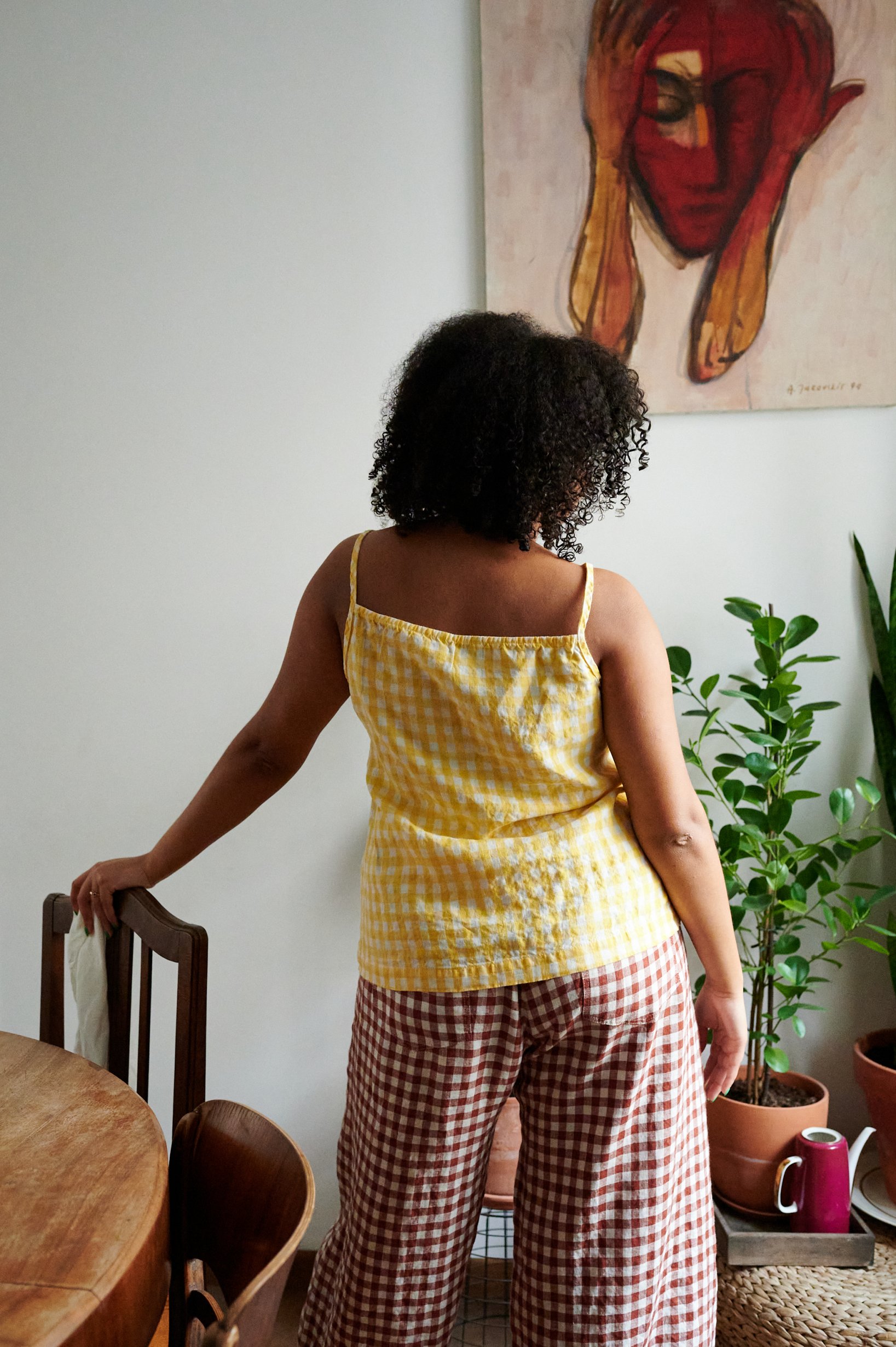 Back of a model wearing a yellow gingham linen sleeveless top