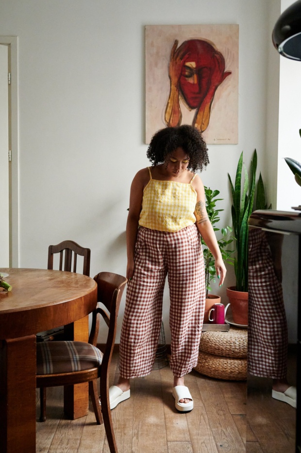 A model in terracotta gingham linen trousers