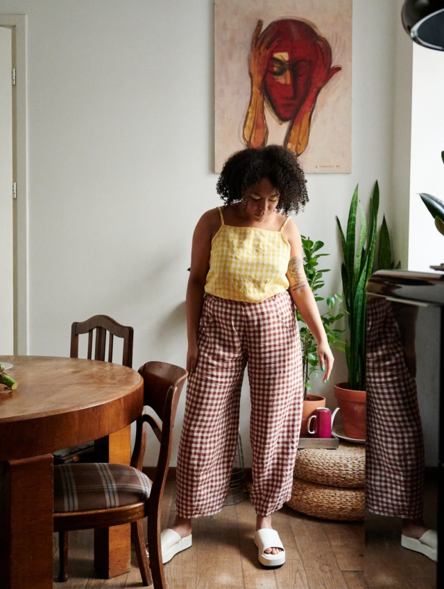 A model in terracotta gingham linen trousers