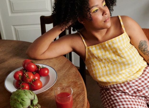 Woman sitting while wearing a gingham linen top and trousers outfit