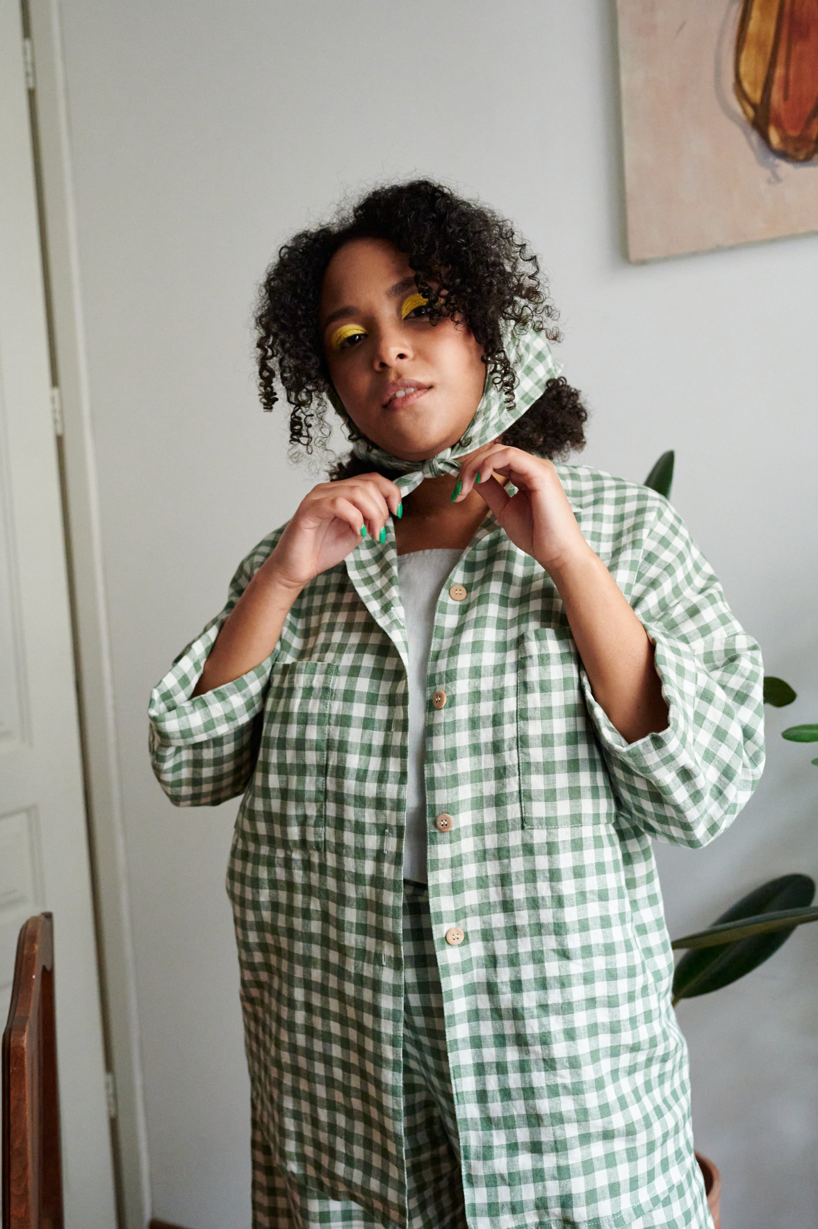 A woman in green gingham linen button down