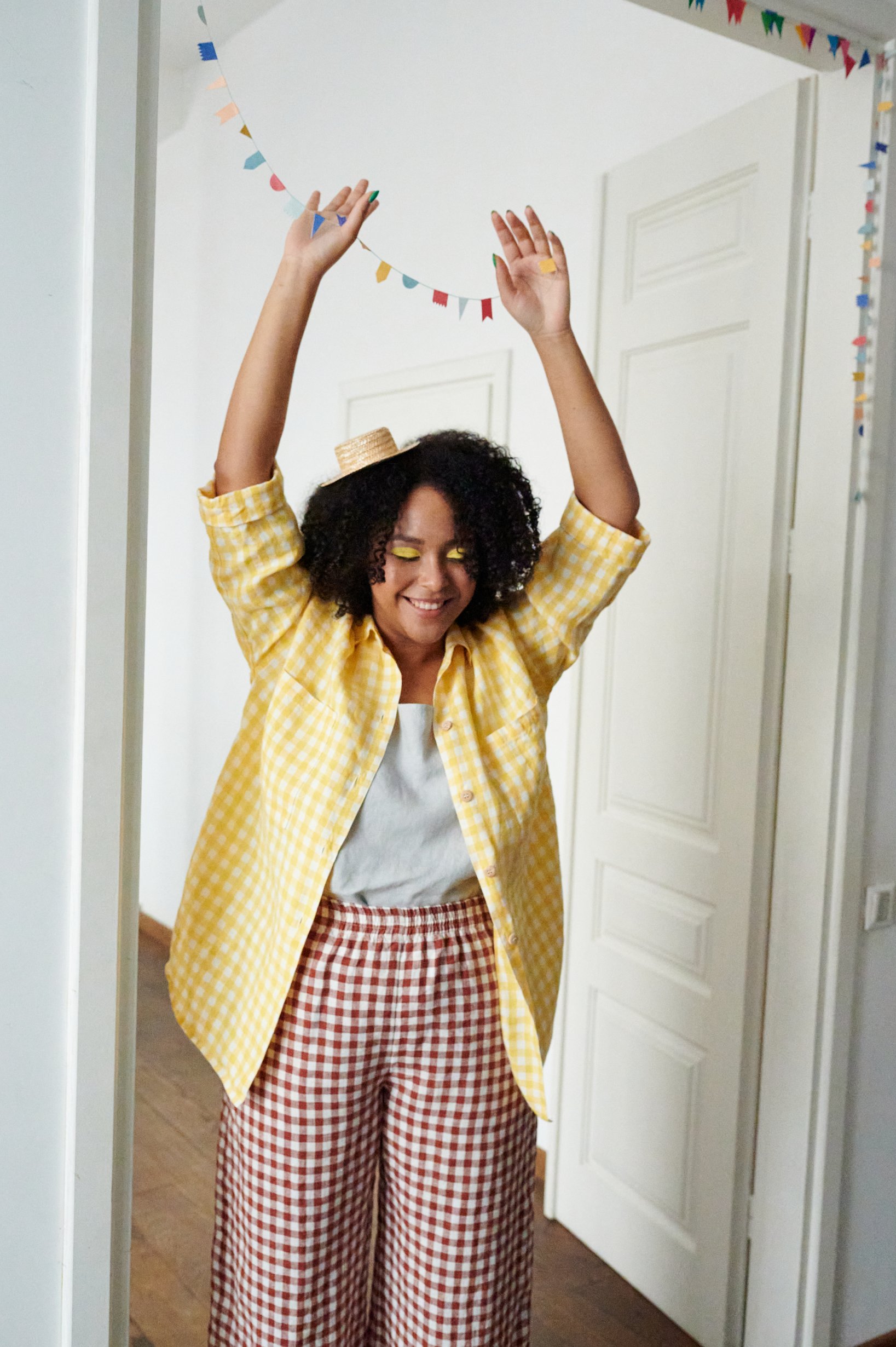 A woman in oversized line button down shirt in yellow gingham
