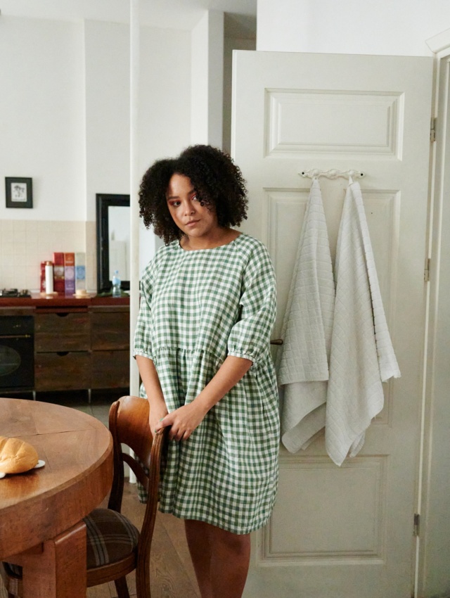 Women wearing green gingham dress at home