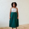 Linenfox model standing in a room, in linen midi full green skirt