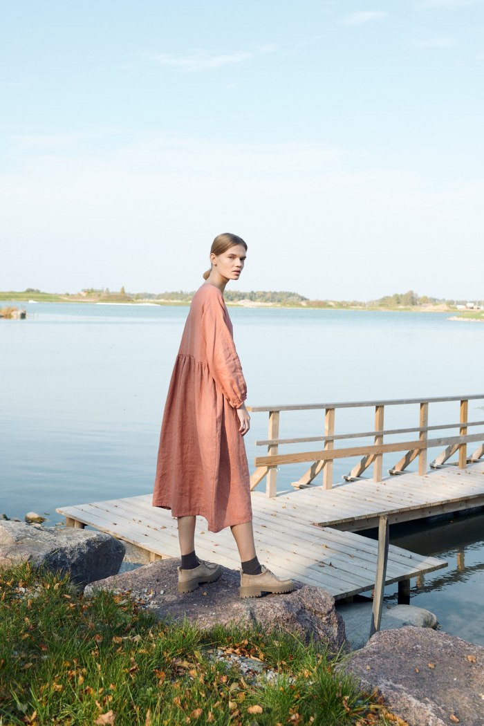 A woman in dark coral oversized linen dress