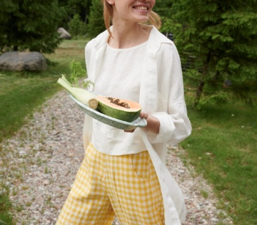 A woman walking in yellow gingham linen pants