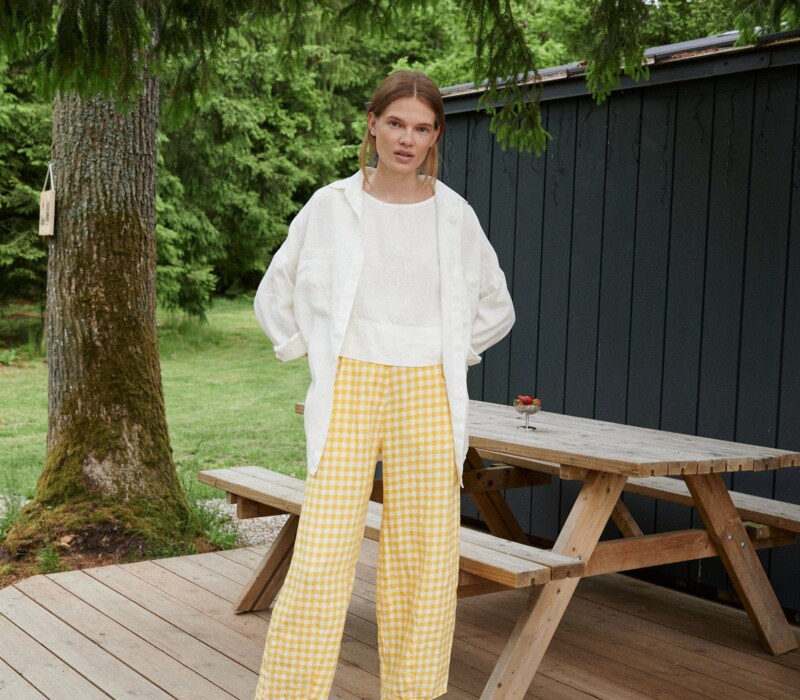 A woman in yellow gingham barrel leg linen trousers