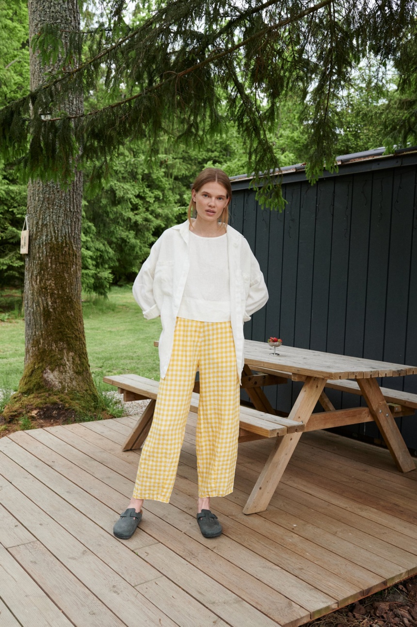 A woman in yellow gingham barrel leg linen trousers