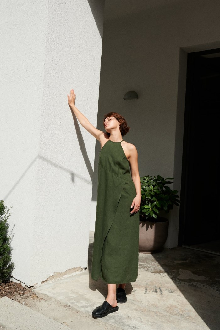 A maxi forest green linen dress with a halter neck and an overlapping skirt