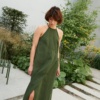 Model in a maxi green linen dress with an overlapping skirt
