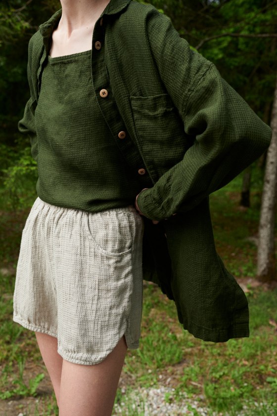 Woman wearing an oversized green waffle linen shirt with a matching linen top and natural grey linen shorts