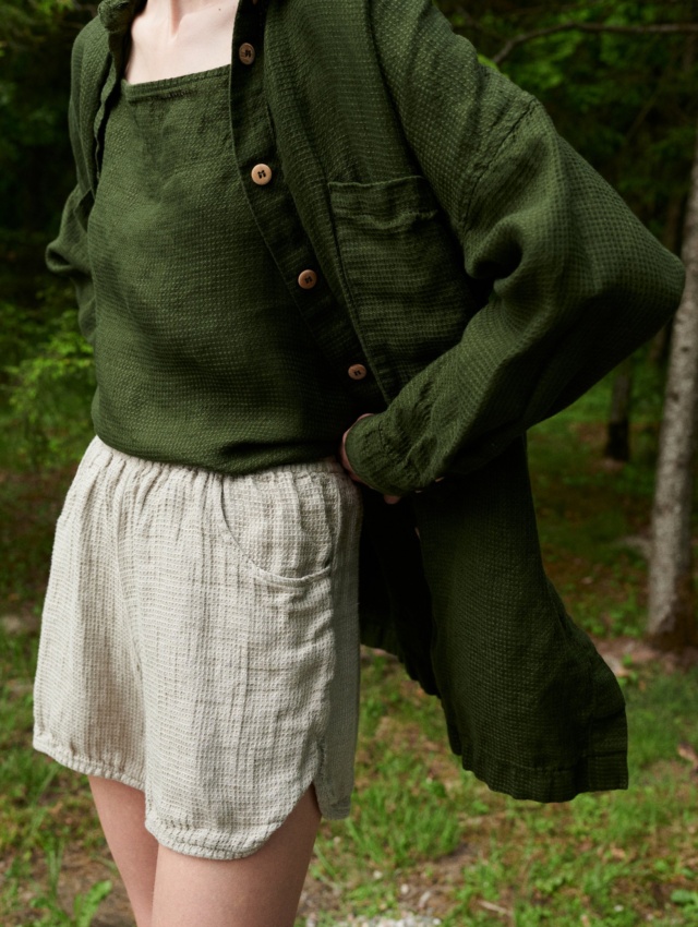 Woman wearing an oversized green waffle linen shirt with a matching linen top and natural grey linen shorts