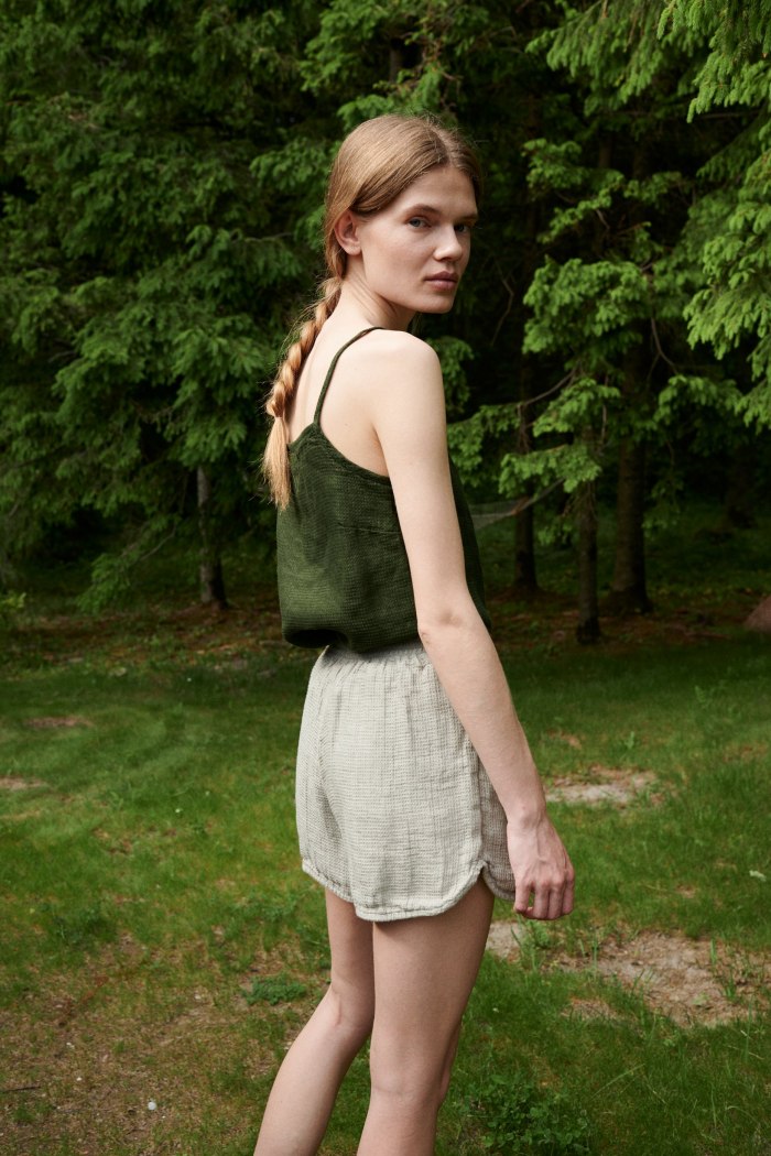 Woman wearing a waffle linen summer top tucked into linen shorts