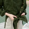 A loose fitting dark green waffle linen button down shirt with wooden buttons