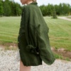 Model walking while wearing an oversized forest green waffle linen shirt