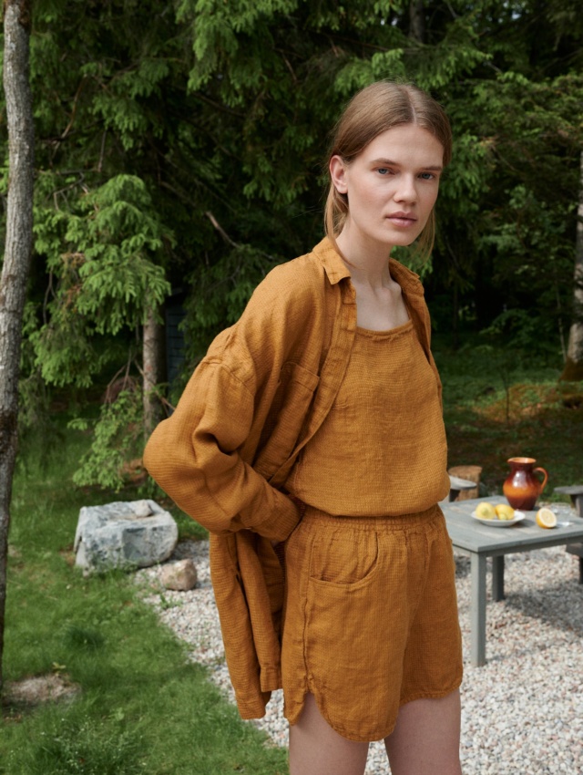 Woman in an oversized waffle linen shirt paired with matching linen summer top and shorts outfit