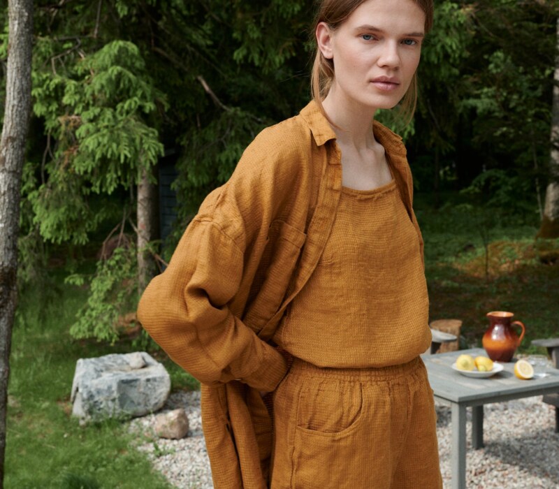 Woman in an oversized waffle linen shirt paired with matching linen summer top and shorts outfit