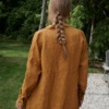 Back of a model in a loose fitting waffle-like textured linen shirt