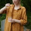Woman wearing an oversized waffle linen button down shirt with a matching linen summer top and shorts