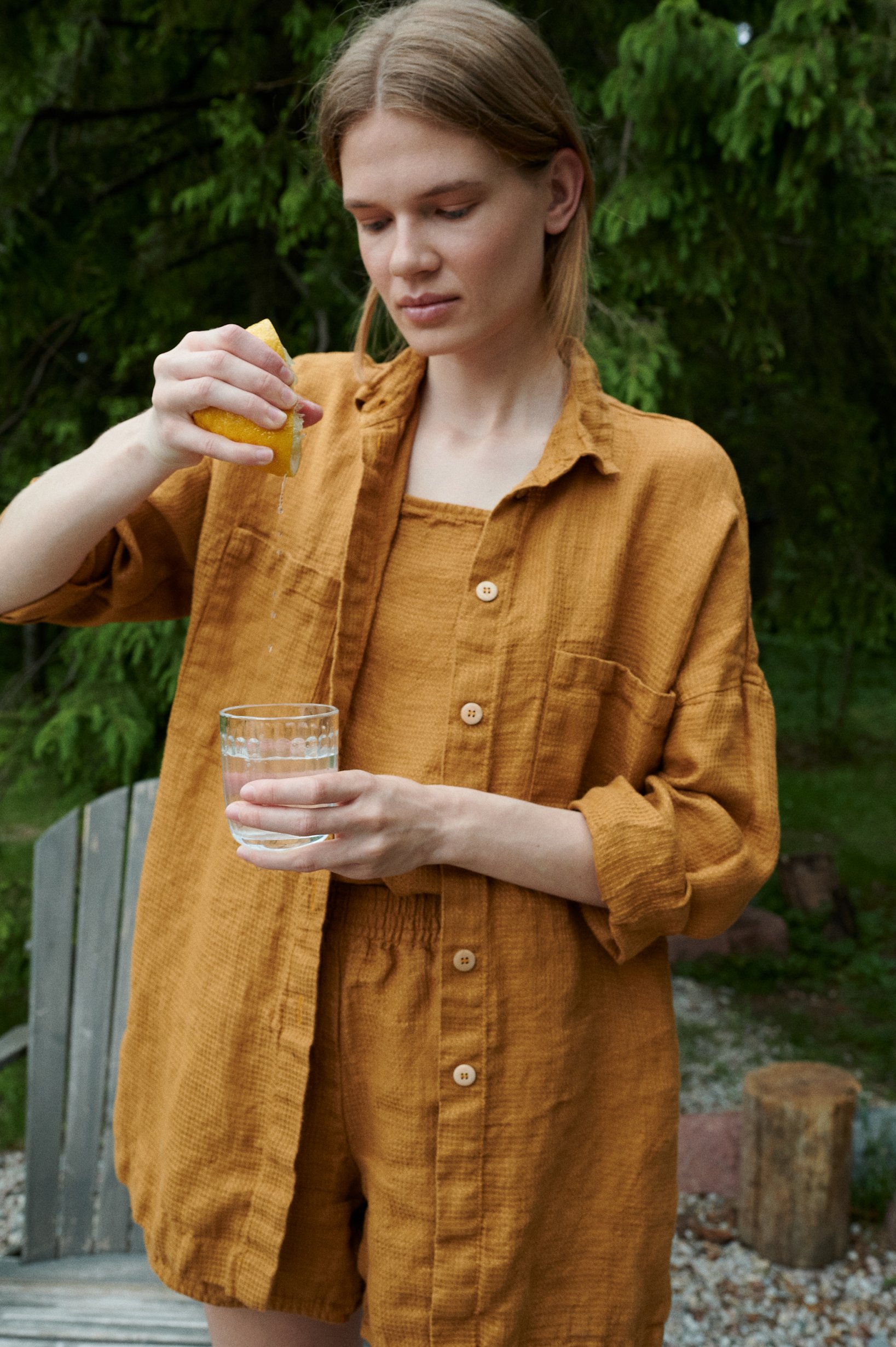 Woman wearing an oversized waffle linen button down shirt with a matching linen summer top and shorts