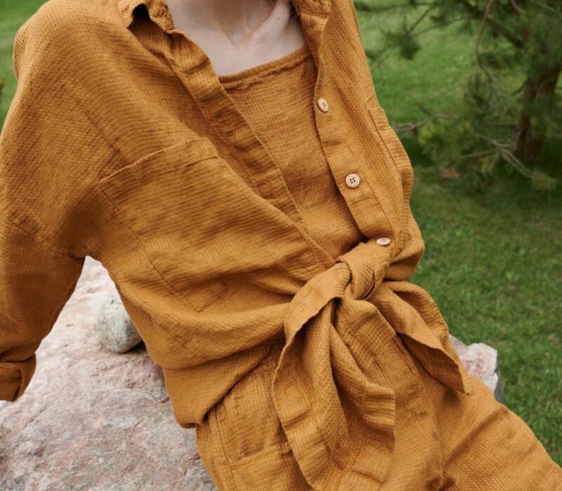 An oversized waffle-like textured linen button down shirt tied in the front