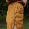 Side view of dark yellow waffle linen shorts with a curved hem and pockets