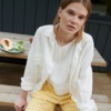 A model sitting in white linen button down shirt