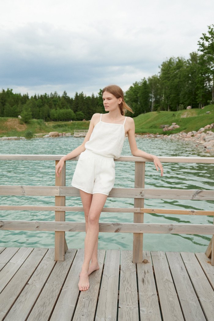 Model in a white linen summer top and matching linen shorts