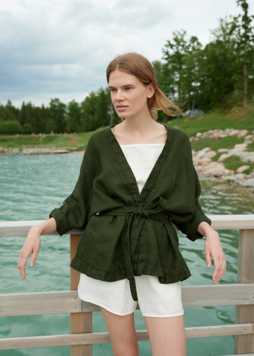 Woman wearing an oversized waffle linen jacket paired with a white linen summer top and shorts
